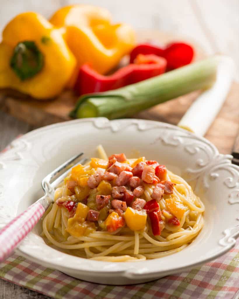 Spaghetti con peperoni, porri e pancetta