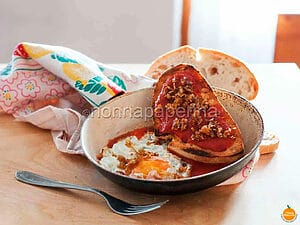 Uovo su crostone di pane al sugo con porri caramellati