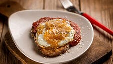 Uovo su crostone di pane al sugo, un antipasto delizioso