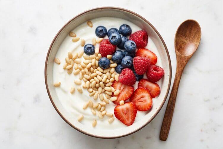Colazione sana con pinoli mirtilli fragole e yogurt
