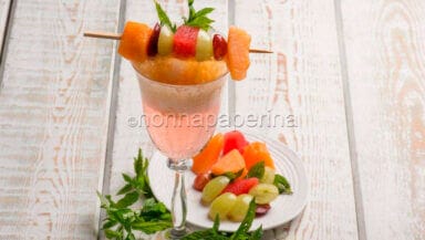 Aperitivo con bollicine spuma di pesca e spiedino di frutta frizzante