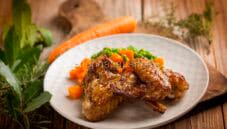 Alette di pollo con contorno di piselli e carote Alette di pollo con contorno di piselli e carote