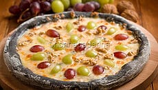 Pizza nera con uva e taleggio