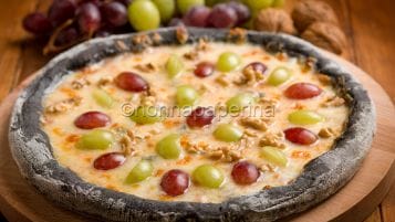 Pizza nera con uva e taleggio