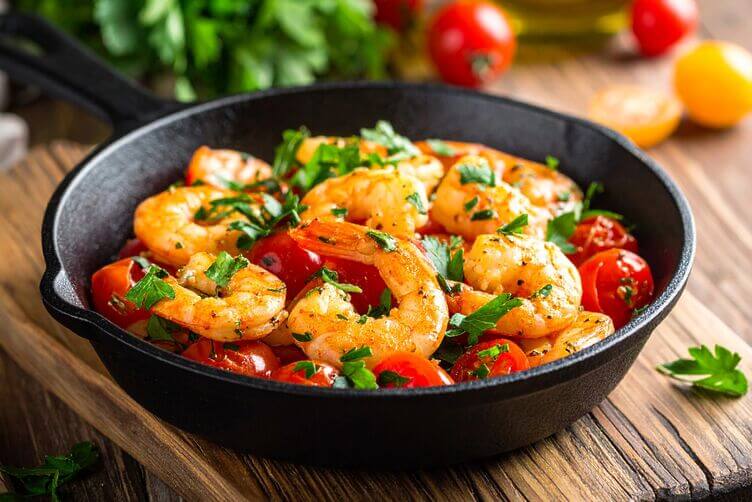 gamberoni in padella con pomodorini freschi, olio extravergine e prezzemolo tritat