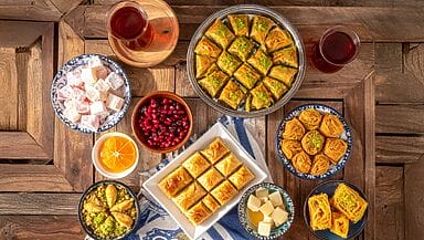 dolci turchi :baklava , lokum (rahat), tulumba şekerpare revani, kunefe coppette di sütlaç e kazandibi, una ciotola di aşure con frutta secca e chicchi di melograno, e fili di pişmaniye