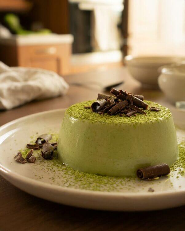 Panna cotta al matcha sformata con trucioli di cioccolato fondente o