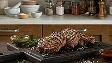 Carne alla griglia marinata servita su tagliere con salsa barbecue