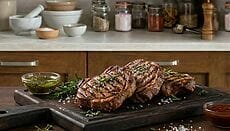 Carne alla griglia marinata servita su tagliere con salsa barbecue